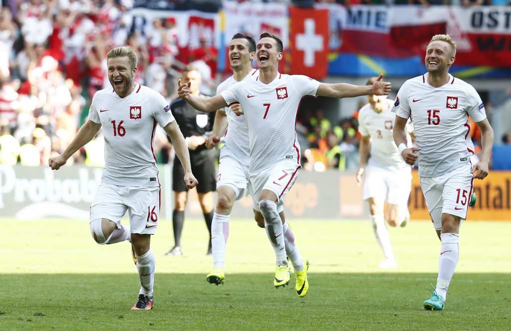 Poland's Jakub Blaszczykowski, Arkadiusz Milik and Kamil Glik celebrate winning the penalty shootout against Switzerland. REUTERS/Kai Pfaffenbach