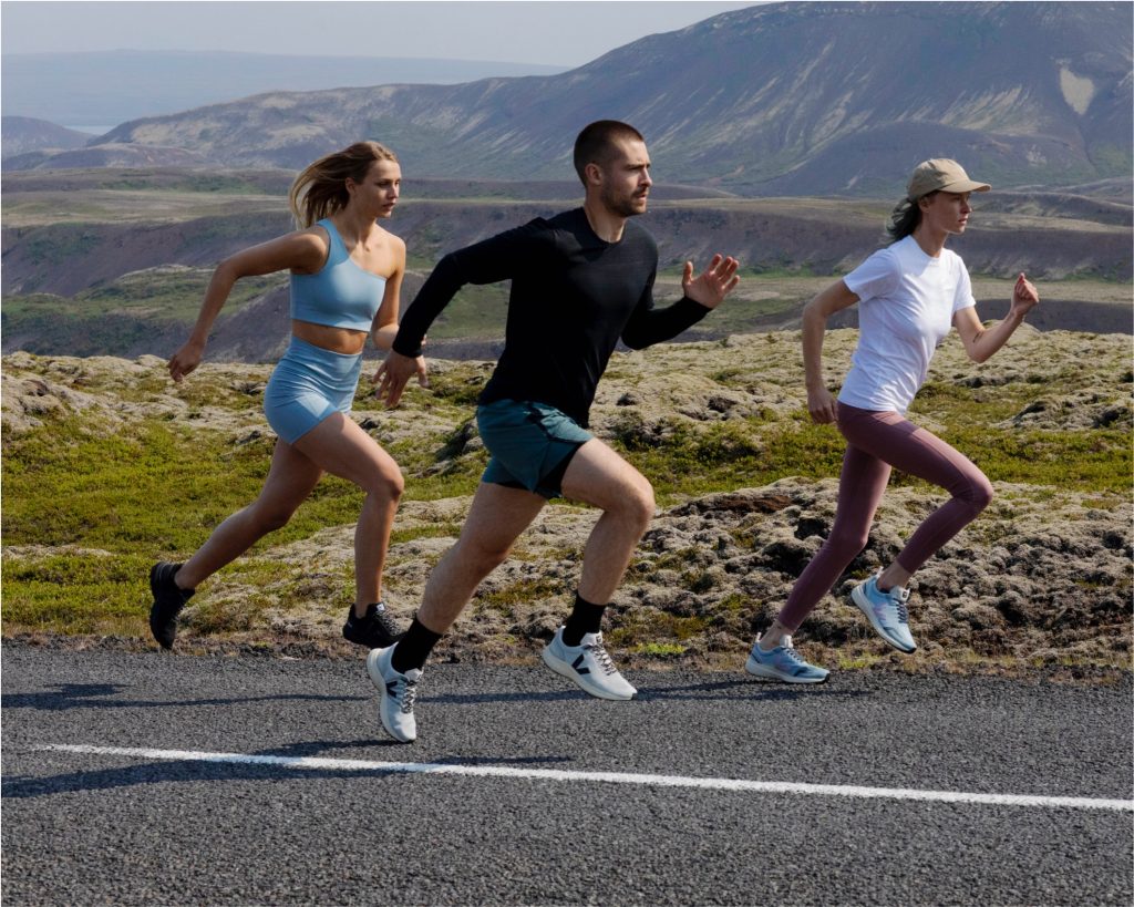 Three runners, two female, one male, wearing veja running shoes