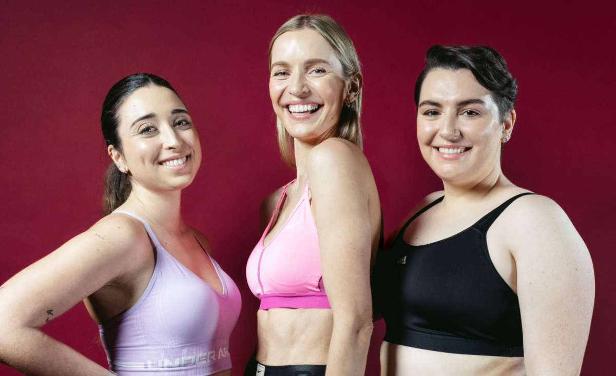 Three models laughing, looking at the camera, with sports bras on.